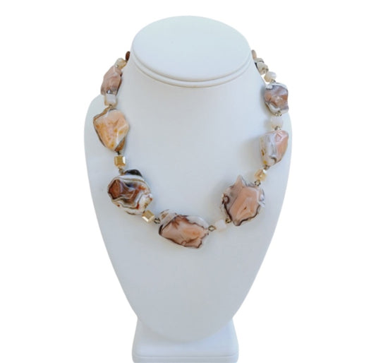 Pink Botswana Agate Necklace featuring chunky pastel gemstone beads handcrafted into a short statement necklace for women. This handmade natural crystal jewelry piece showcases soft pink and cream hues, offering calming and healing properties. Perfect as a thoughtful gift, it adds a delicate yet bold touch to any outfit. Lightweight and versatile, this unique necklace blends artisanal craftsmanship with boho elegance, ideal for everyday wear or special occasions.