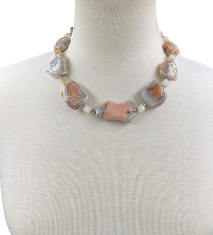 Pink Botswana Agate Necklace featuring chunky pastel gemstone beads handcrafted into a short statement necklace for women. This handmade natural crystal jewelry piece showcases soft pink and cream hues, offering calming and healing properties. Perfect as a thoughtful gift, it adds a delicate yet bold touch to any outfit. Lightweight and versatile, this unique necklace blends artisanal craftsmanship with boho elegance, ideal for everyday wear or special occasions.
