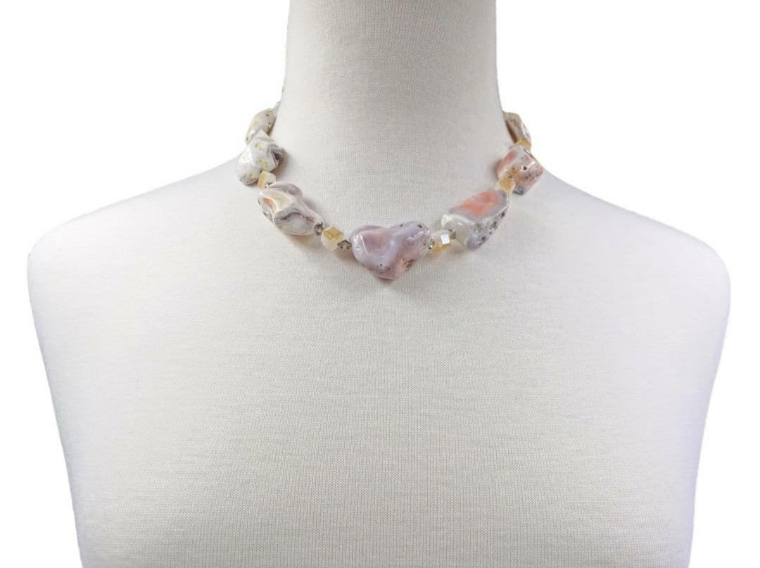 Pink Botswana Agate Necklace featuring chunky pastel gemstone beads handcrafted into a short statement necklace for women. This handmade natural crystal jewelry piece showcases soft pink and cream hues, offering calming and healing properties. Perfect as a thoughtful gift, it adds a delicate yet bold touch to any outfit. Lightweight and versatile, this unique necklace blends artisanal craftsmanship with boho elegance, ideal for everyday wear or special occasions.
