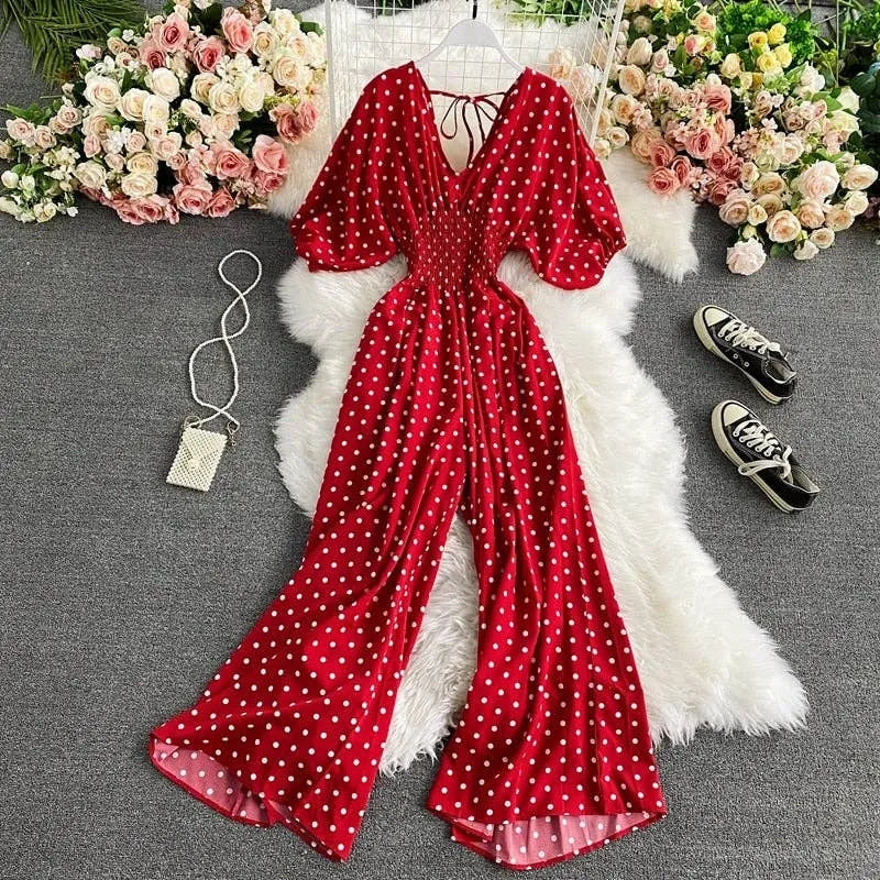 Brown, red, and white polka dot jumpsuit for women featuring a sexy V-neck, puff short sleeves, and a loose, wide-leg design for comfortable wear. This high-waisted one-piece outfit is made in the USA and combines playful patterns with a flattering silhouette. Ideal for casual outings, parties, or summer events, the breathable fabric and stylish cut make it a versatile and chic wardrobe addition.