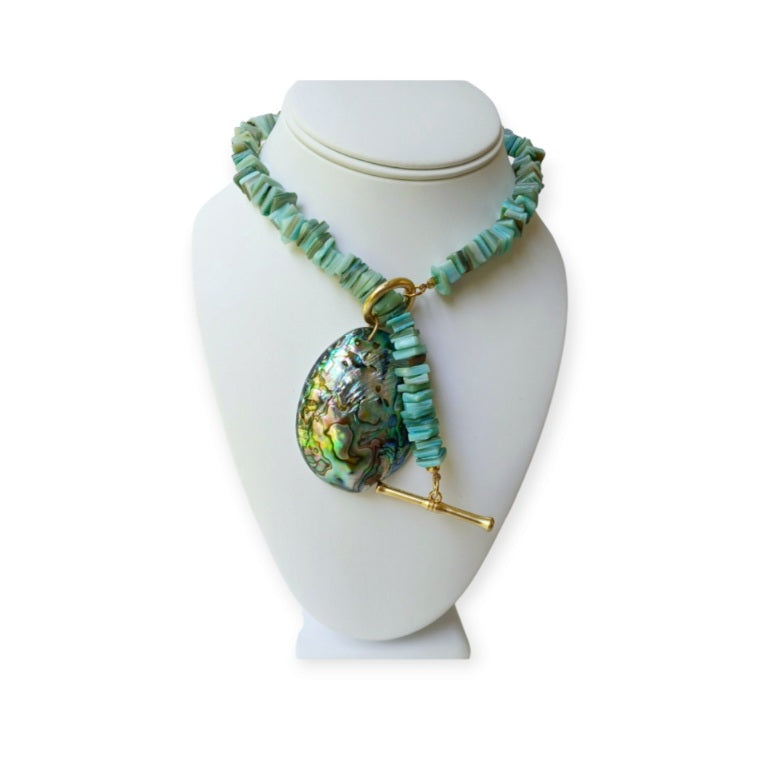 Sage green necklace featuring turquoise chips and a stunning abalone peacock seashell pendant, perfect for boho ocean-inspired style. This coastal beach vibes jewelry piece blends natural tones with iridescent shimmer, ideal for sea lovers and nature enthusiasts. A thoughtful gift for her, it adds earthy elegance to summer outfits, festivals, or casual wear. Handmade charm meets mermaid magic in this coastal chic accessory