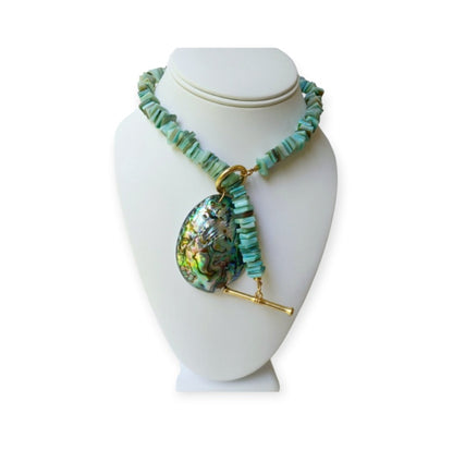 Sage green necklace featuring turquoise chips and a stunning abalone peacock seashell pendant, perfect for boho ocean-inspired style. This coastal beach vibes jewelry piece blends natural tones with iridescent shimmer, ideal for sea lovers and nature enthusiasts. A thoughtful gift for her, it adds earthy elegance to summer outfits, festivals, or casual wear. Handmade charm meets mermaid magic in this coastal chic accessory