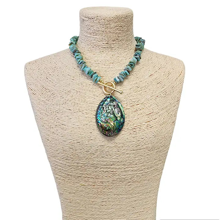 Sage green necklace featuring turquoise chips and a stunning abalone peacock seashell pendant, perfect for boho ocean-inspired style. This coastal beach vibes jewelry piece blends natural tones with iridescent shimmer, ideal for sea lovers and nature enthusiasts. A thoughtful gift for her, it adds earthy elegance to summer outfits, festivals, or casual wear. Handmade charm meets mermaid magic in this coastal chic accessory
