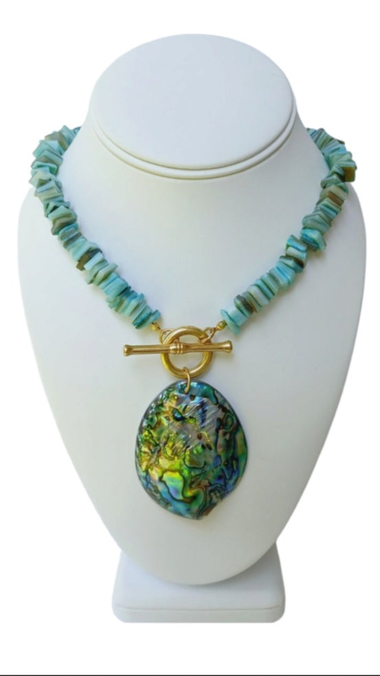 Sage green necklace featuring turquoise chips and a stunning abalone peacock seashell pendant, perfect for boho ocean-inspired style. This coastal beach vibes jewelry piece blends natural tones with iridescent shimmer, ideal for sea lovers and nature enthusiasts. A thoughtful gift for her, it adds earthy elegance to summer outfits, festivals, or casual wear. Handmade charm meets mermaid magic in this coastal chic accessory