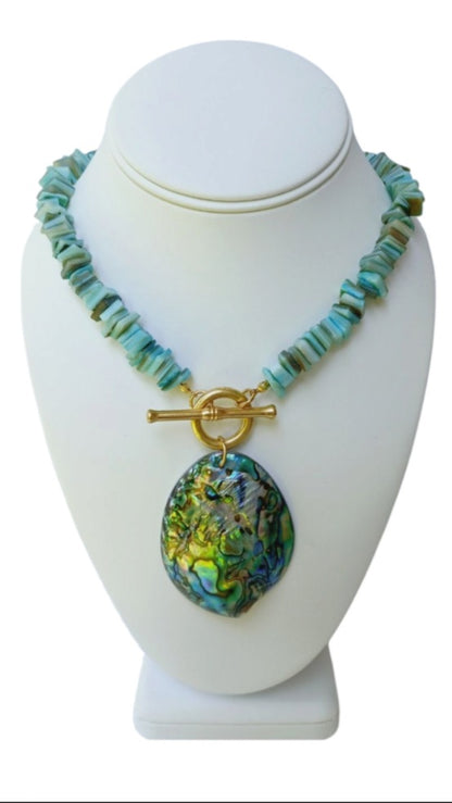 Sage green necklace featuring turquoise chips and a stunning abalone peacock seashell pendant, perfect for boho ocean-inspired style. This coastal beach vibes jewelry piece blends natural tones with iridescent shimmer, ideal for sea lovers and nature enthusiasts. A thoughtful gift for her, it adds earthy elegance to summer outfits, festivals, or casual wear. Handmade charm meets mermaid magic in this coastal chic accessory