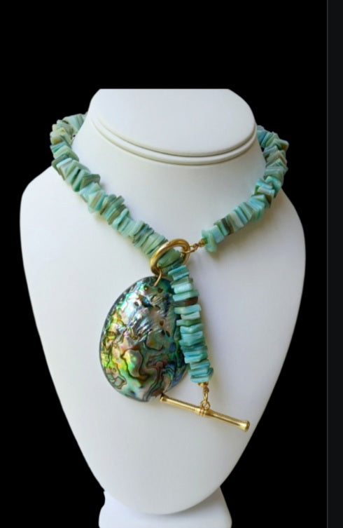 Sage green necklace featuring turquoise chips and a stunning abalone peacock seashell pendant, perfect for boho ocean-inspired style. This coastal beach vibes jewelry piece blends natural tones with iridescent shimmer, ideal for sea lovers and nature enthusiasts. A thoughtful gift for her, it adds earthy elegance to summer outfits, festivals, or casual wear. Handmade charm meets mermaid magic in this coastal chic accessory
