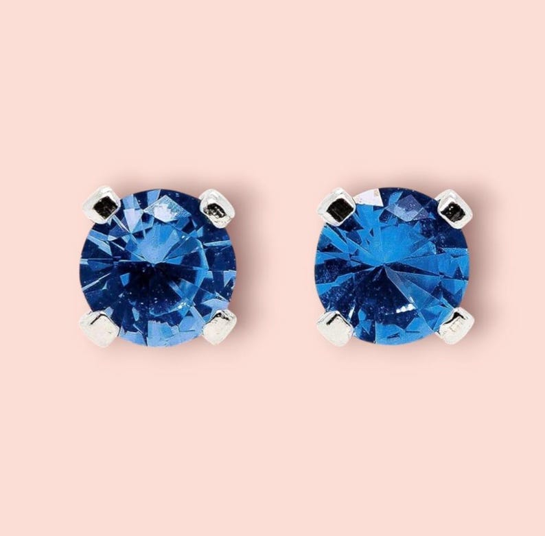 Blue Sapphire Sterling Silver Stud Earrings featuring dazzling deep blue gemstones in a minimalist setting. These elegant birthstone earrings are perfect for women who love dainty, timeless jewelry with meaningful detail. Ideal as a September birthday or anniversary gift, they offer a refined, sophisticated touch for everyday wear or special occasions.Handcrafted with care, these studs make a thoughtful gift for her, blending simplicity, elegance, and personal significance in one classic design.