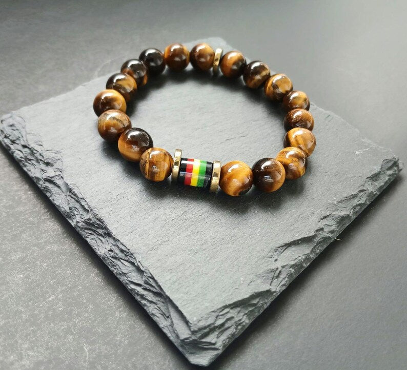 Tiger Eye Bracelet for men featuring a handmade design inspired by Rastafarian and reggae culture, crafted to promote protection, prosperity, and strength. This lucky mantra jewelry combines earthy Tiger Eye beads with bold, vibrant accents for a spiritual yet stylish look. Perfect for daily wear or meaningful gifting, it’s ideal for those seeking grounding energy and cultural expression. A powerful accessory with deep symbolism and unique design.