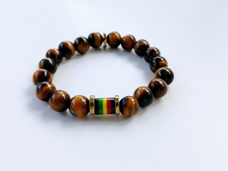 Tiger Eye Bracelet for men featuring a handmade design inspired by Rastafarian and reggae culture, crafted to promote protection, prosperity, and strength. This lucky mantra jewelry combines earthy Tiger Eye beads with bold, vibrant accents for a spiritual yet stylish look. Perfect for daily wear or meaningful gifting, it’s ideal for those seeking grounding energy and cultural expression. A powerful accessory with deep symbolism and unique design.