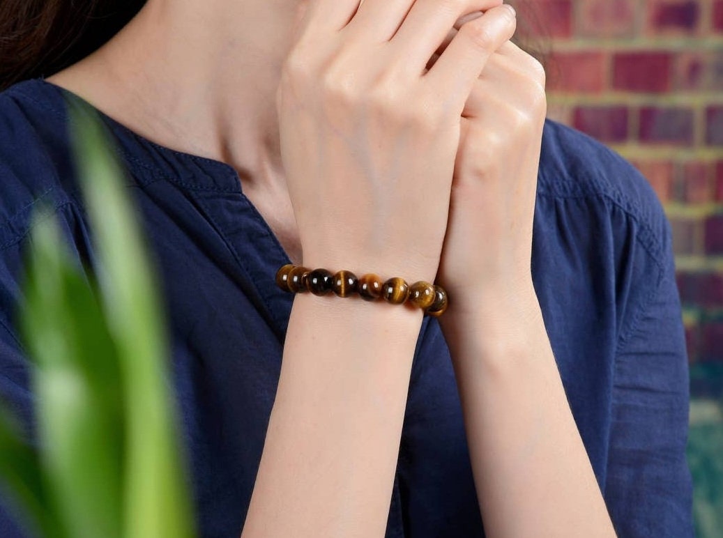 Tiger Eye Bracelet for men featuring natural healing crystals known for protection, strength, and balance. This stylish spiritual jewelry is designed to promote positive energy and calm, making it a meaningful gift for him—perfect for husbands or boyfriends. Handmade with quality beads, it combines durability and fashion for everyday wear. Ideal for meditation, casual outfits, or special occasions, blending wellness with masculine style.
