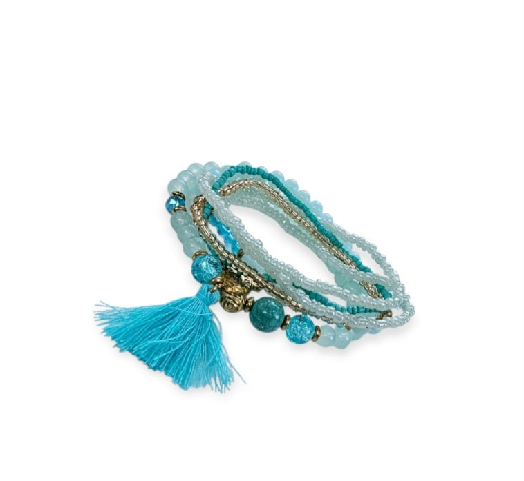 Turquoise Ocean Stacks Bracelet featuring layered blue beads, healing stones, and a playful charm tassel design. This handmade boho bracelet for women and girls offers a vibrant, beachy vibe inspired by ocean waves and coastal energy. Perfect for everyday wear, festivals, or beach vacations, it combines spiritual healing with carefree style. A thoughtful gift for her, this bohemian jewelry piece adds color, positivity, and charm to any casual or summer-inspired look.