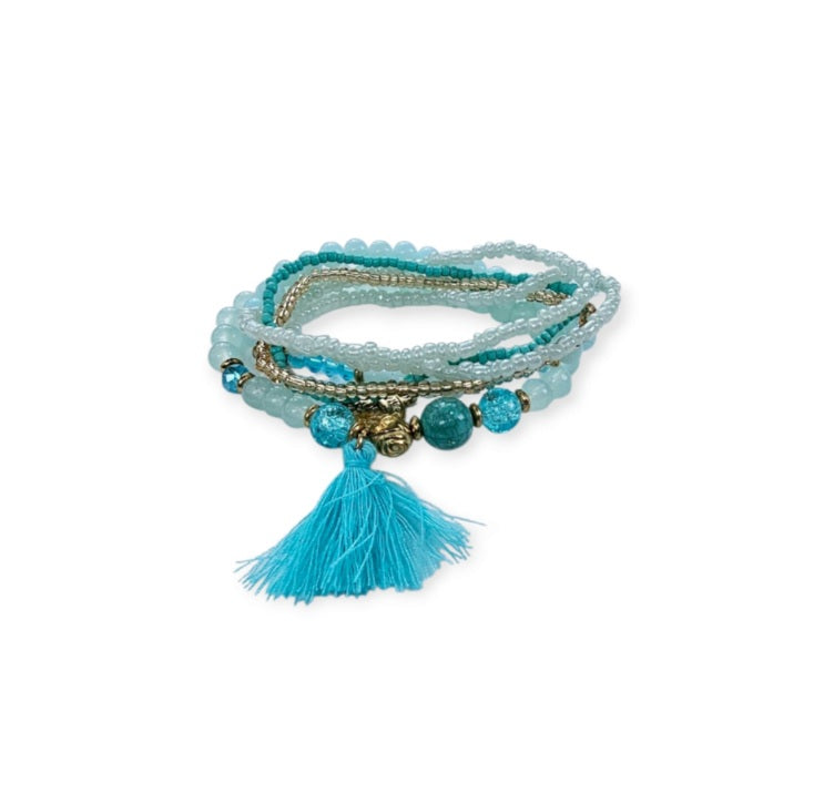 Turquoise Ocean Stacks Bracelet featuring layered blue beads, healing stones, and a playful charm tassel design. This handmade boho bracelet for women and girls offers a vibrant, beachy vibe inspired by ocean waves and coastal energy. Perfect for everyday wear, festivals, or beach vacations, it combines spiritual healing with carefree style. A thoughtful gift for her, this bohemian jewelry piece adds color, positivity, and charm to any casual or summer-inspired look.