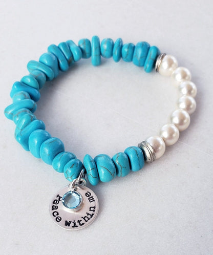Turquoise & Freshwater Pearl Bracelet featuring a handmade design that blends vibrant turquoise stones with lustrous freshwater pearls. This inspirational healing jewelry is perfect for women seeking balance and positive energy, making it an ideal birthstone gift for December. The statement bracelet combines natural beauty and artisanal craftsmanship, adding a stylish boho touch to any outfit. Lightweight and elegant, it’s suitable for everyday wear or special occasions.