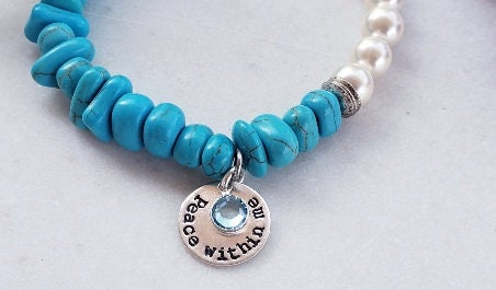 Turquoise & Freshwater Pearl Bracelet featuring a handmade design that blends vibrant turquoise stones with lustrous freshwater pearls. This inspirational healing jewelry is perfect for women seeking balance and positive energy, making it an ideal birthstone gift for December. The statement bracelet combines natural beauty and artisanal craftsmanship, adding a stylish boho touch to any outfit. Lightweight and elegant, it’s suitable for everyday wear or special occasions.