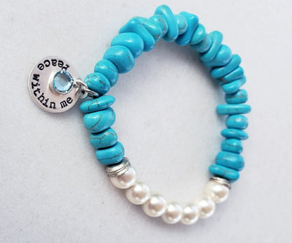 Turquoise & Freshwater Pearl Bracelet featuring a handmade design that blends vibrant turquoise stones with lustrous freshwater pearls. This inspirational healing jewelry is perfect for women seeking balance and positive energy, making it an ideal birthstone gift for December. The statement bracelet combines natural beauty and artisanal craftsmanship, adding a stylish boho touch to any outfit. Lightweight and elegant, it’s suitable for everyday wear or special occasions.